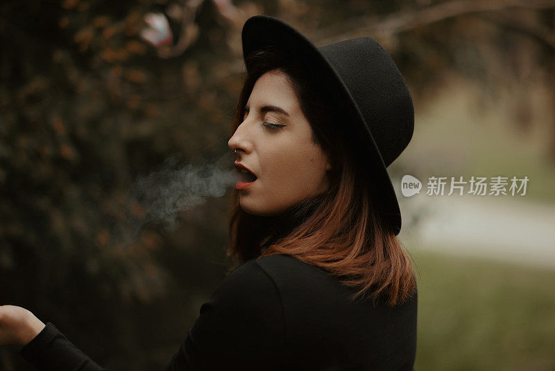 Young redhead woman profile portrait smoking cigarette with eyes closed